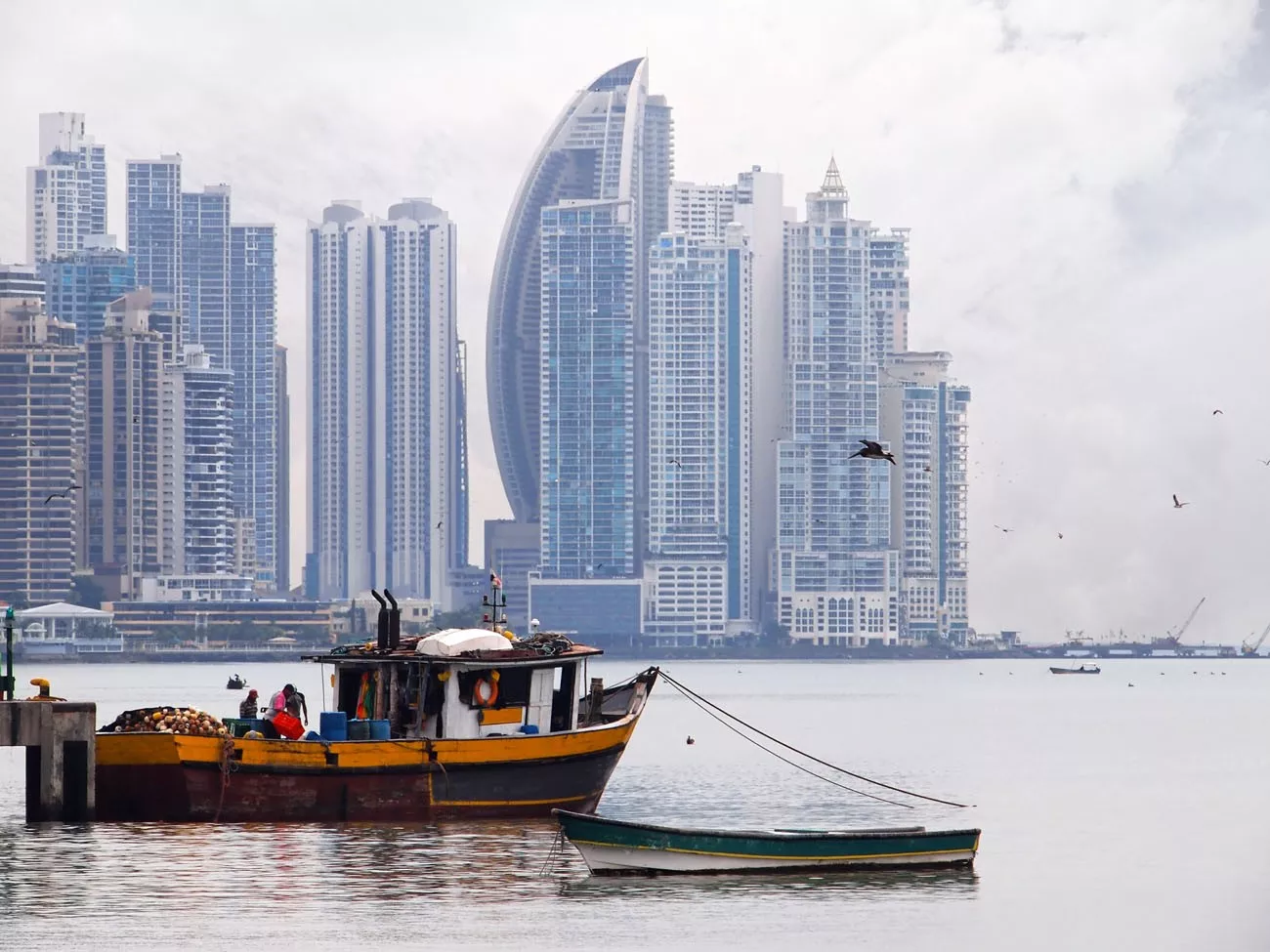 Barco de pesca velho no primeiro plano com arranha-céus no fundo, Cidade do Panamá