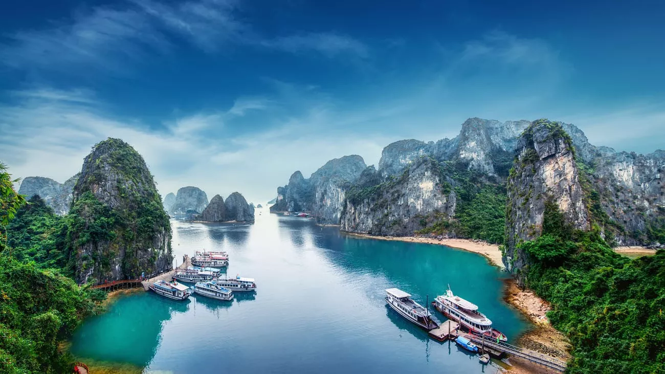 Barcos turisticos flutuando entre rochas calcárias em Ha Long Bay, Mar do Sul da China, Vietnã, sudeste da Ásia
