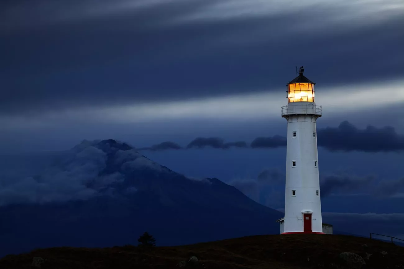 Cape Egmont Farol e Taranaki Mount no fundo, Nova Zelândia