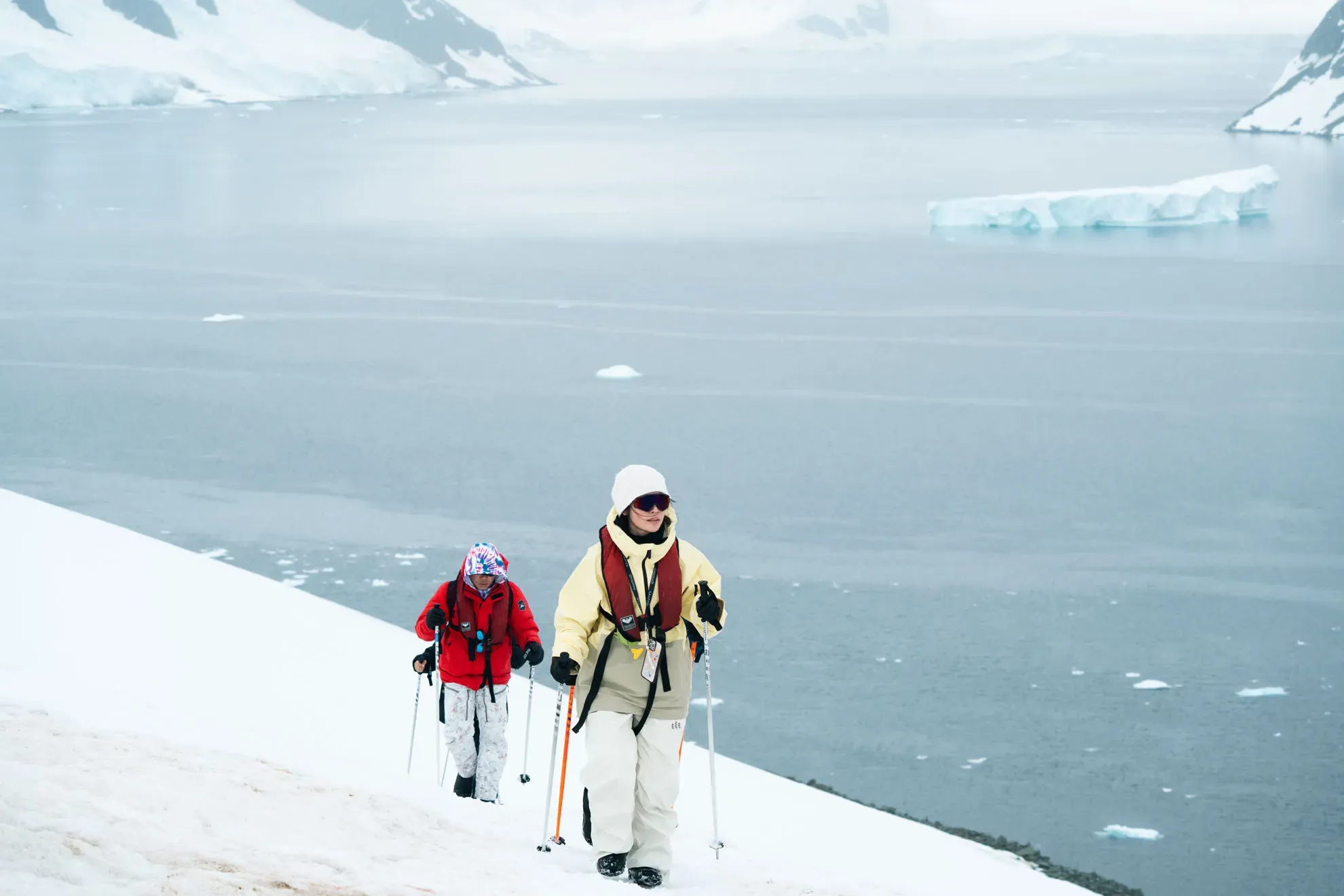 Duas pessoas caminhando na beira do mar Antartida