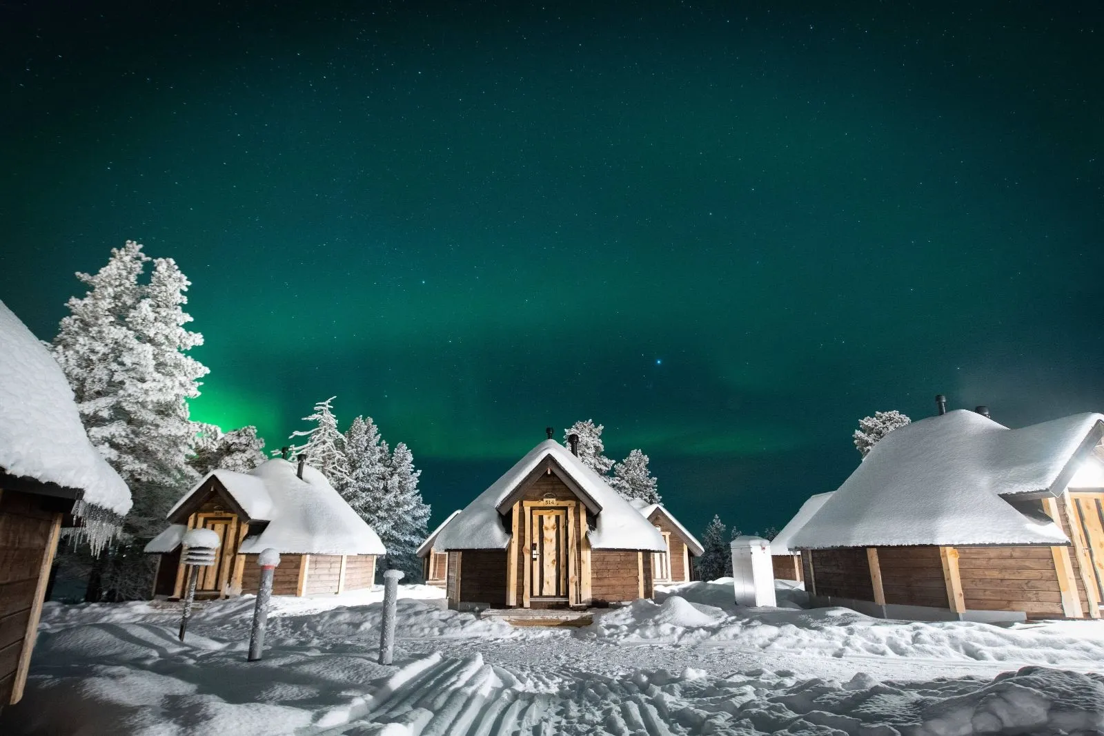 Cabines sob a Aurora Boreal em Saariselka
